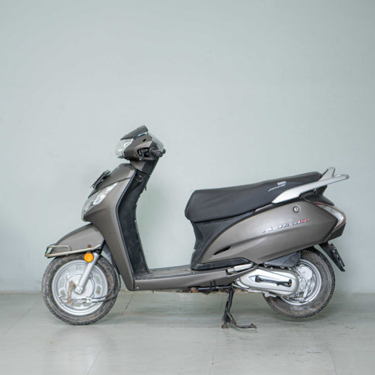 Honda Activa 125 scooter with black and silver body, front view showing headlight and handlebar, by BikeDilwado.