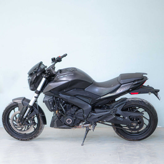 Black Bajaj Dominar 400 motorcycle with sleek design and sporty appearance, displayed on a stand.