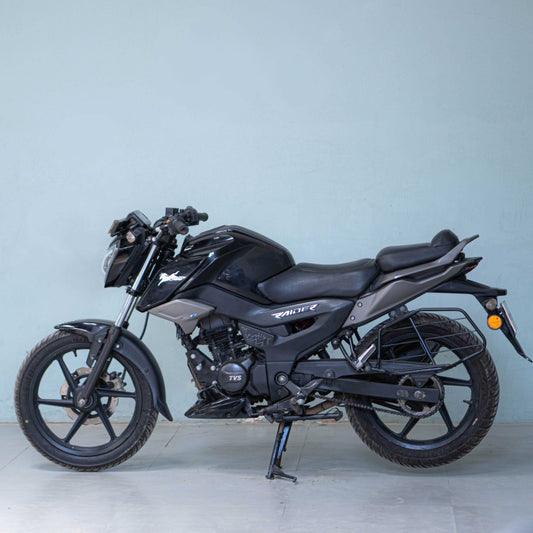 Black TVS Raider 125 motorcycle from BikeDilwado, front view showing headlight and handlebar details.