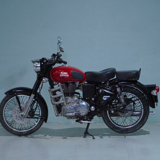 Royal Enfield Classic 350 motorcycle with black finish and vintage design, parked outdoors with a clear sky background.