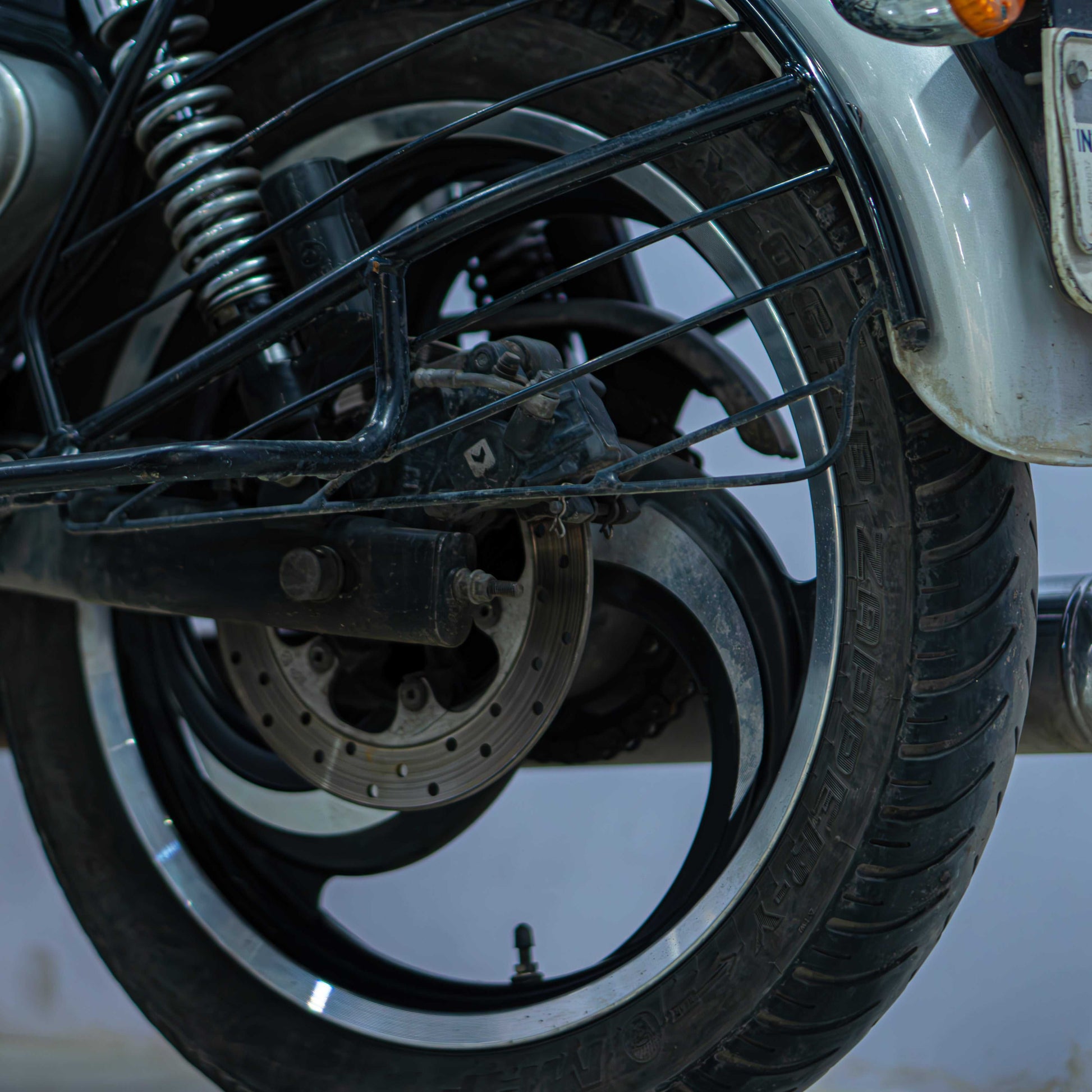 Royal Enfield Classic 350 motorcycle parked on the road, featuring a vintage design with a black and chrome finish.