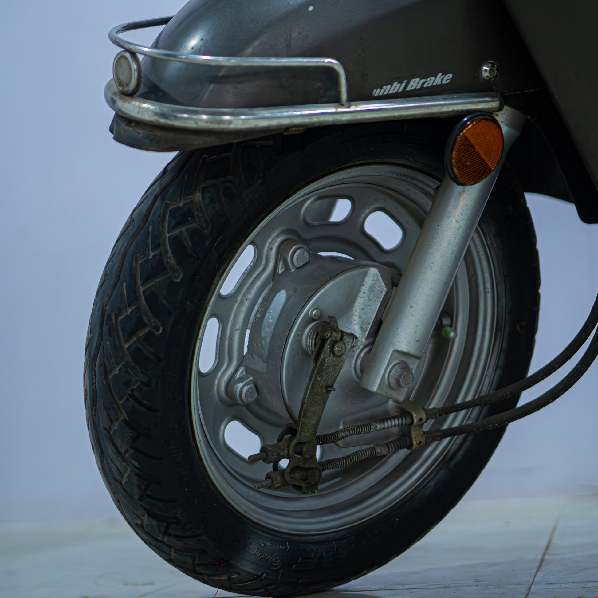 Honda Activa 125 scooter with black body and silver accents, displayed on a stand.