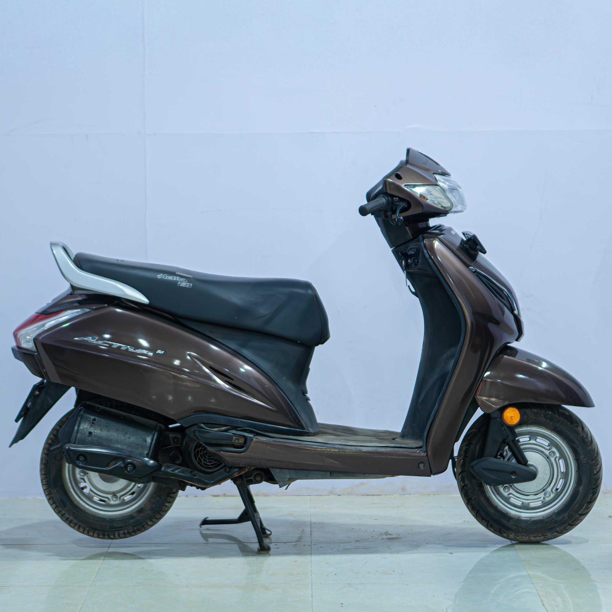 Honda Activa 5G scooter with black body and silver accents, showcasing the front view and handlebar design.