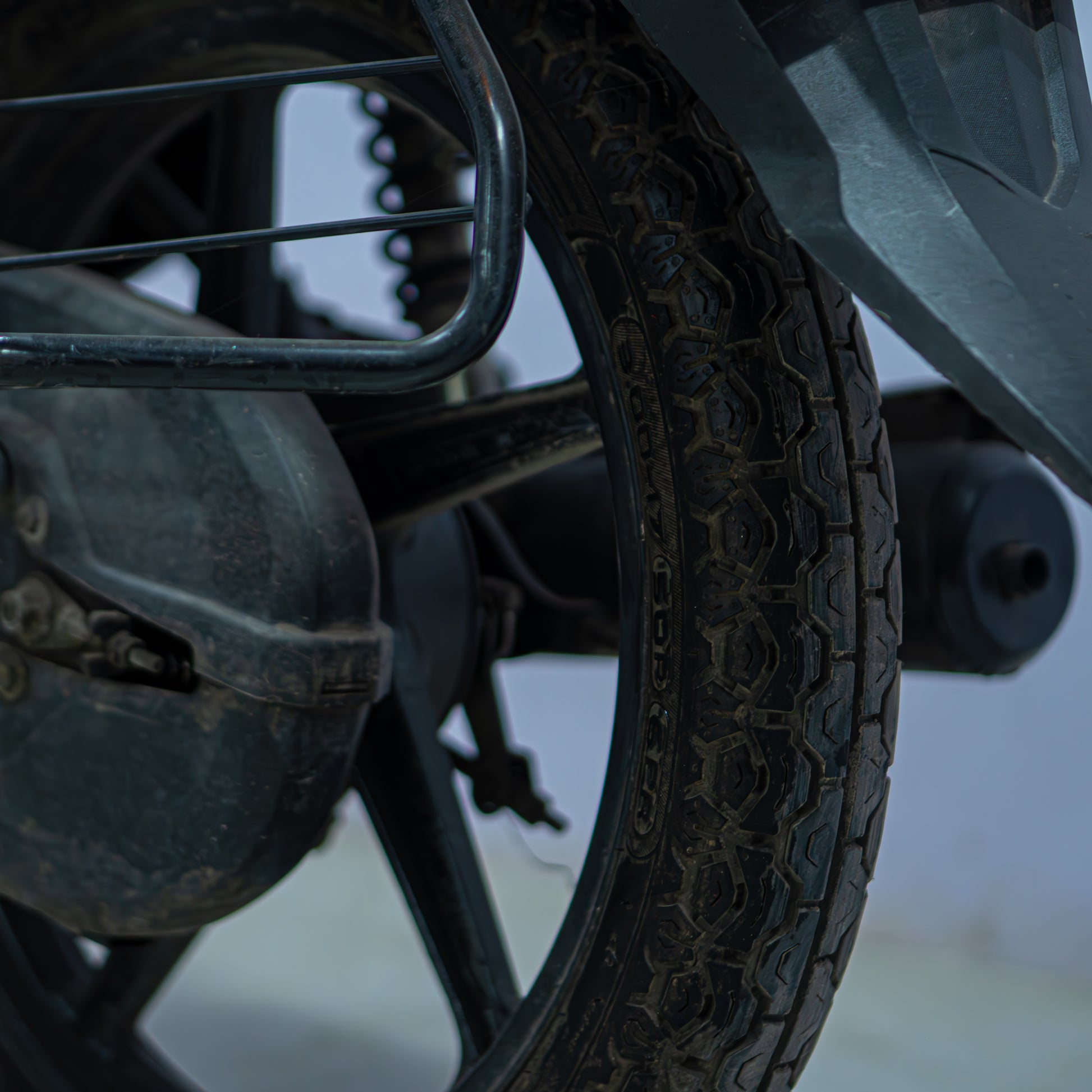 Honda Shine 100 motorcycle from BikeDilwado parked outdoors, showcasing its sleek design and shiny silver body.