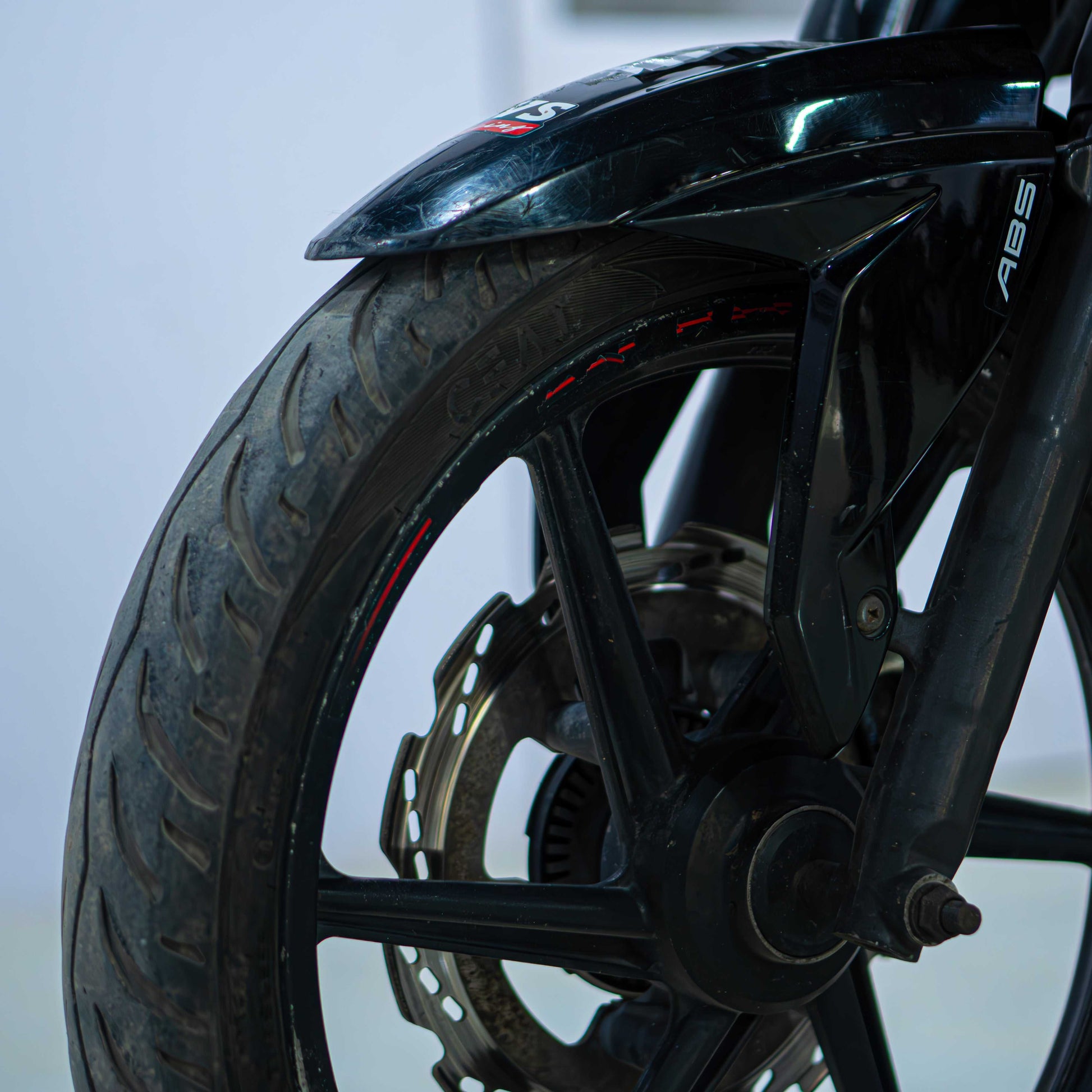 Red TVS Apache 160 4V motorcycle with sporty design and sleek body, parked on a street.