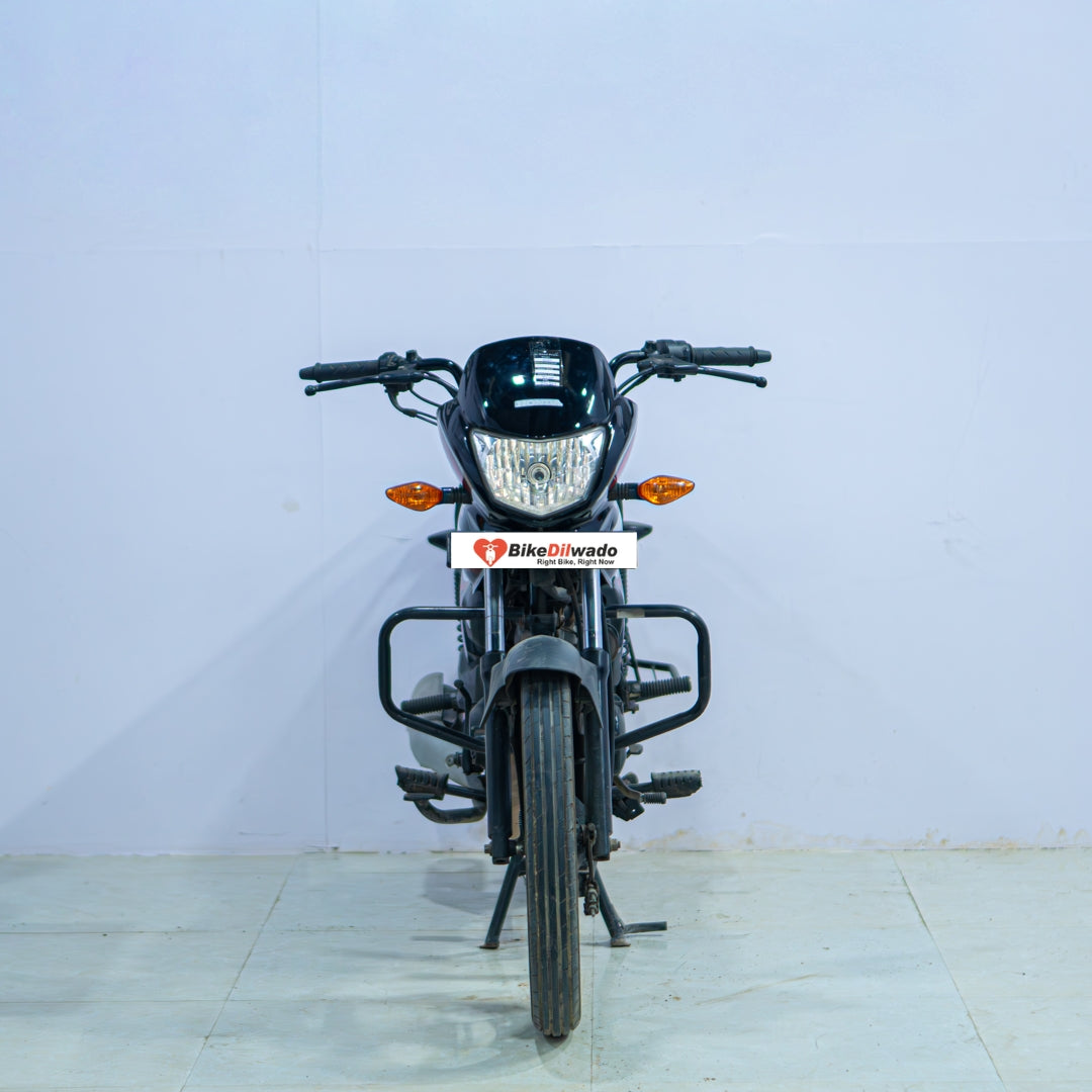 Honda Shine 100 motorcycle from BikeDilwado showing the side view with black and silver bodywork and standard features.