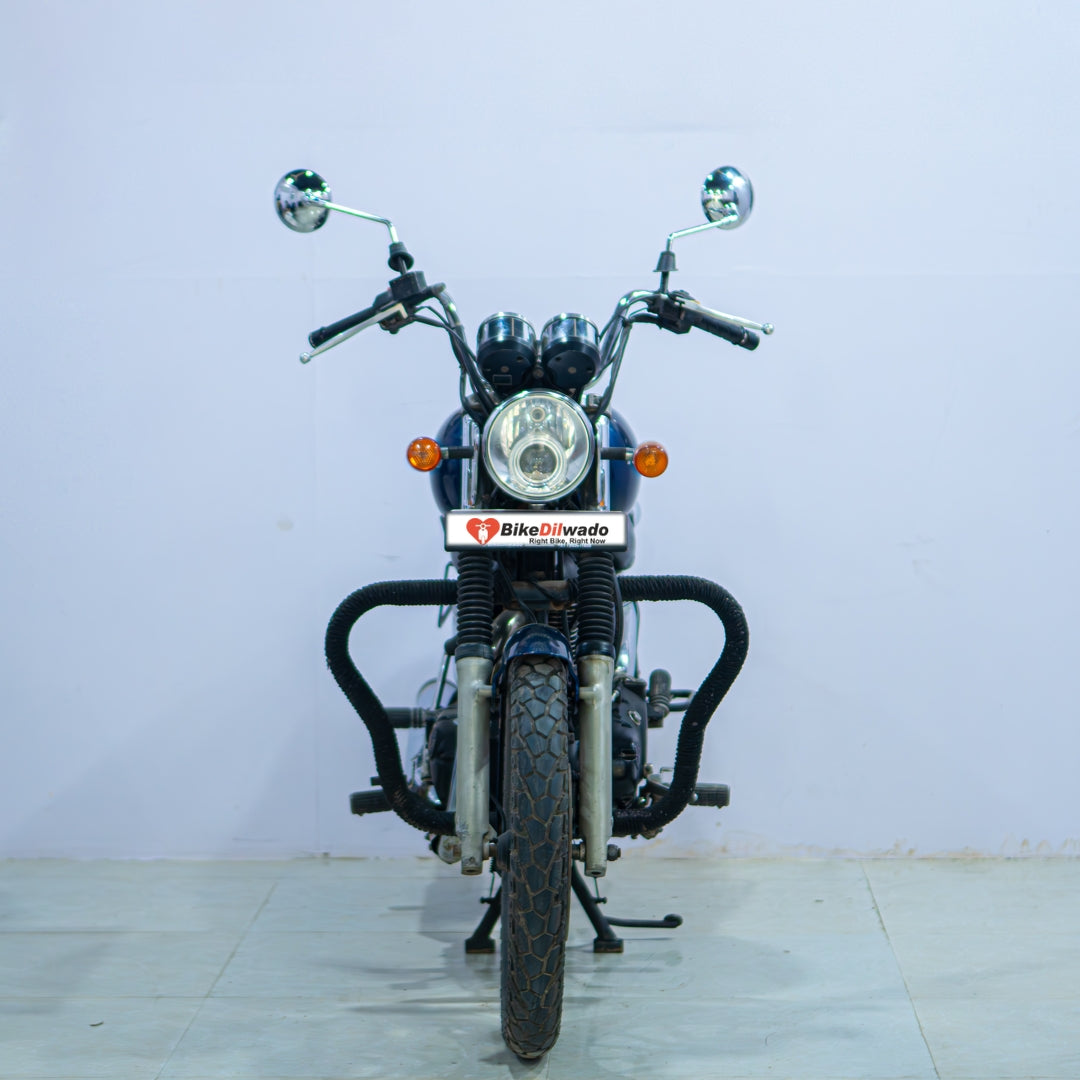 Royal Enfield Thunderbird motorcycle with sleek black body and chrome accents, parked on a scenic road.