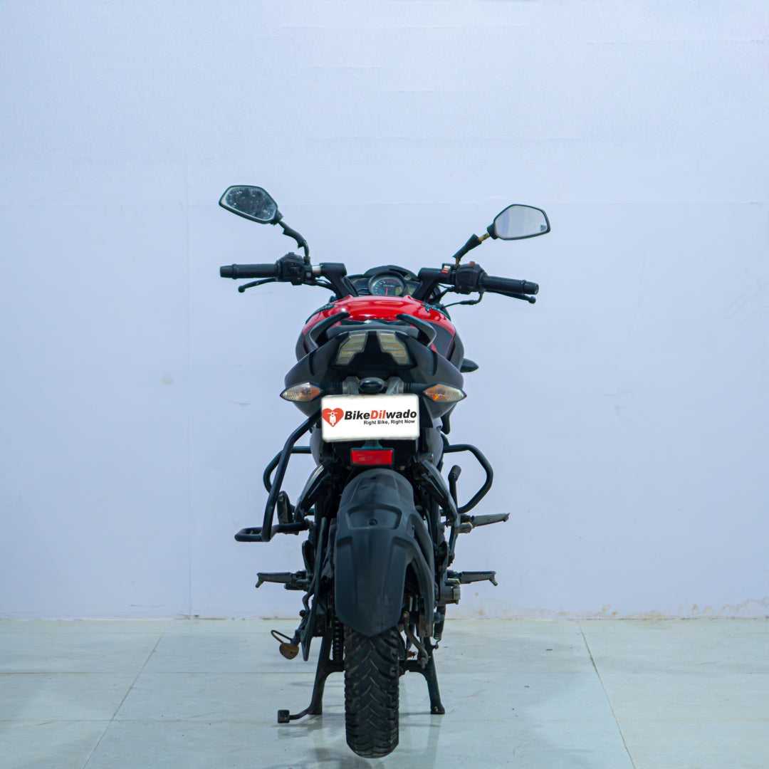 Bajaj NS 160 motorcycle by BikeDilwado, side view showing black and red design, sporty fuel tank, and sleek body panels.