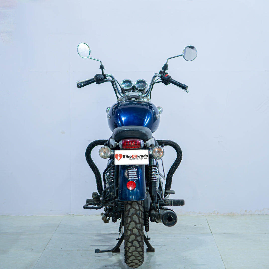 Royal Enfield Thunderbird motorcycle with chrome accents and black body, parked on a scenic road.
