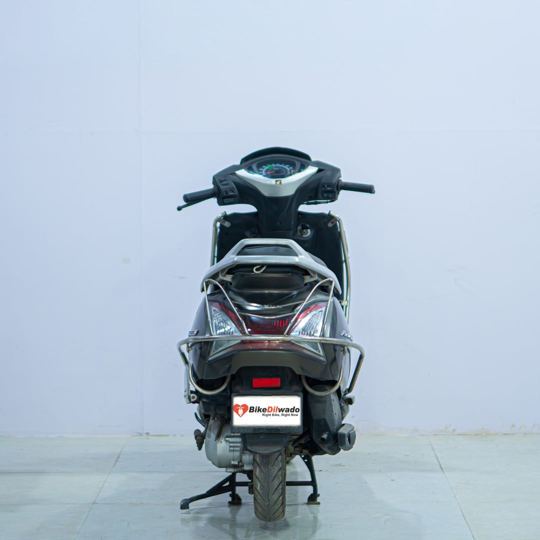 Honda Activa 125 scooter with black body and silver accents, showcasing its sleek design and comfortable seating.
