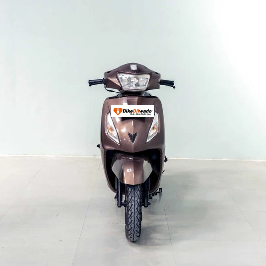 TVS Jupiter scooter with black seat and silver body, parked on a street, showcasing the BikeDilwado logo.
