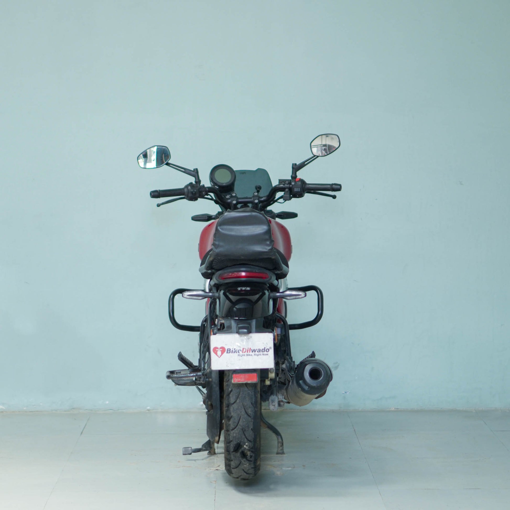 Black TVS Ronin motorcycle with sleek design and modern features, parked outdoors on a paved surface.