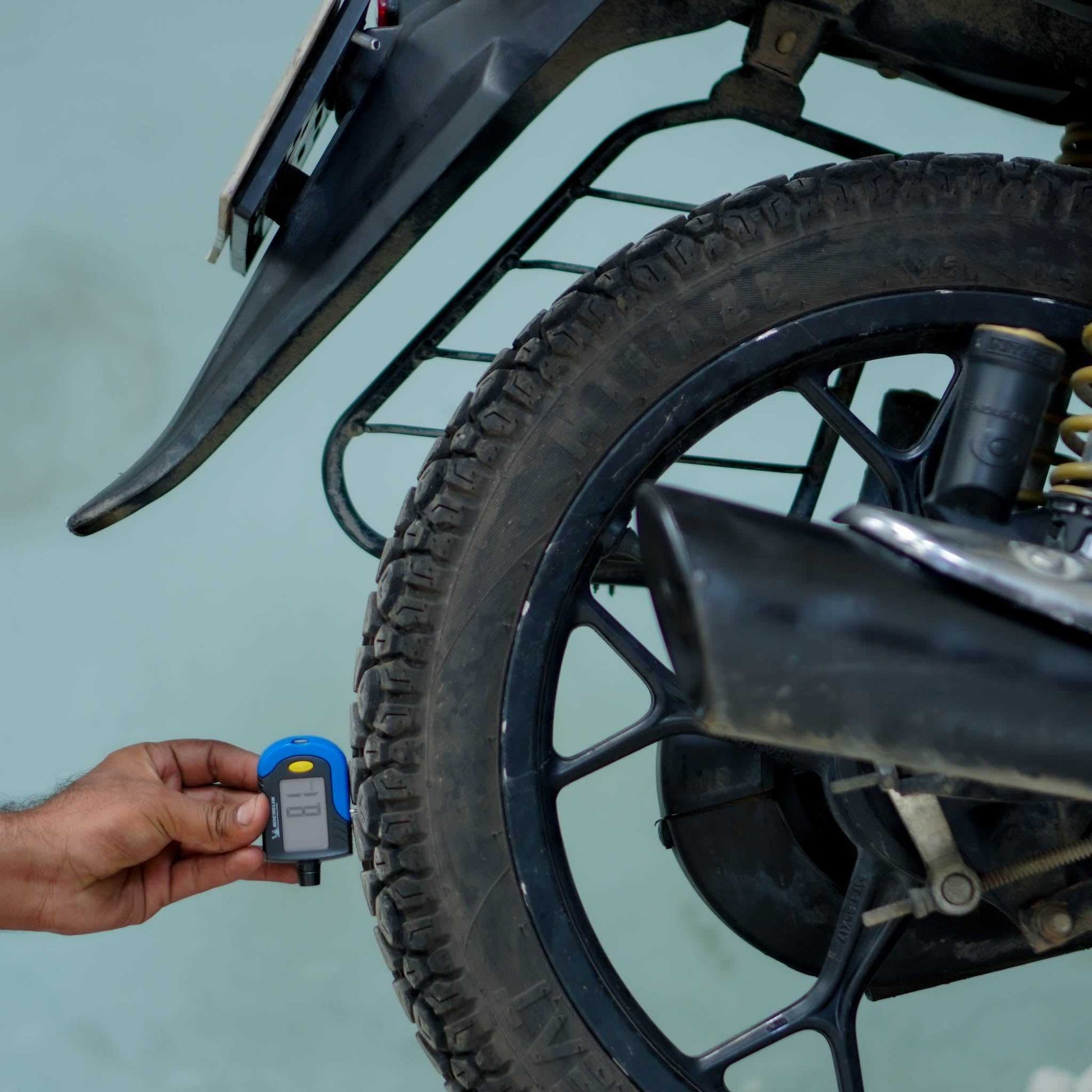 Bajaj Platina motorcycle parked on a road, showcasing the sleek design and durable build of the BikeDilwado branded bike.