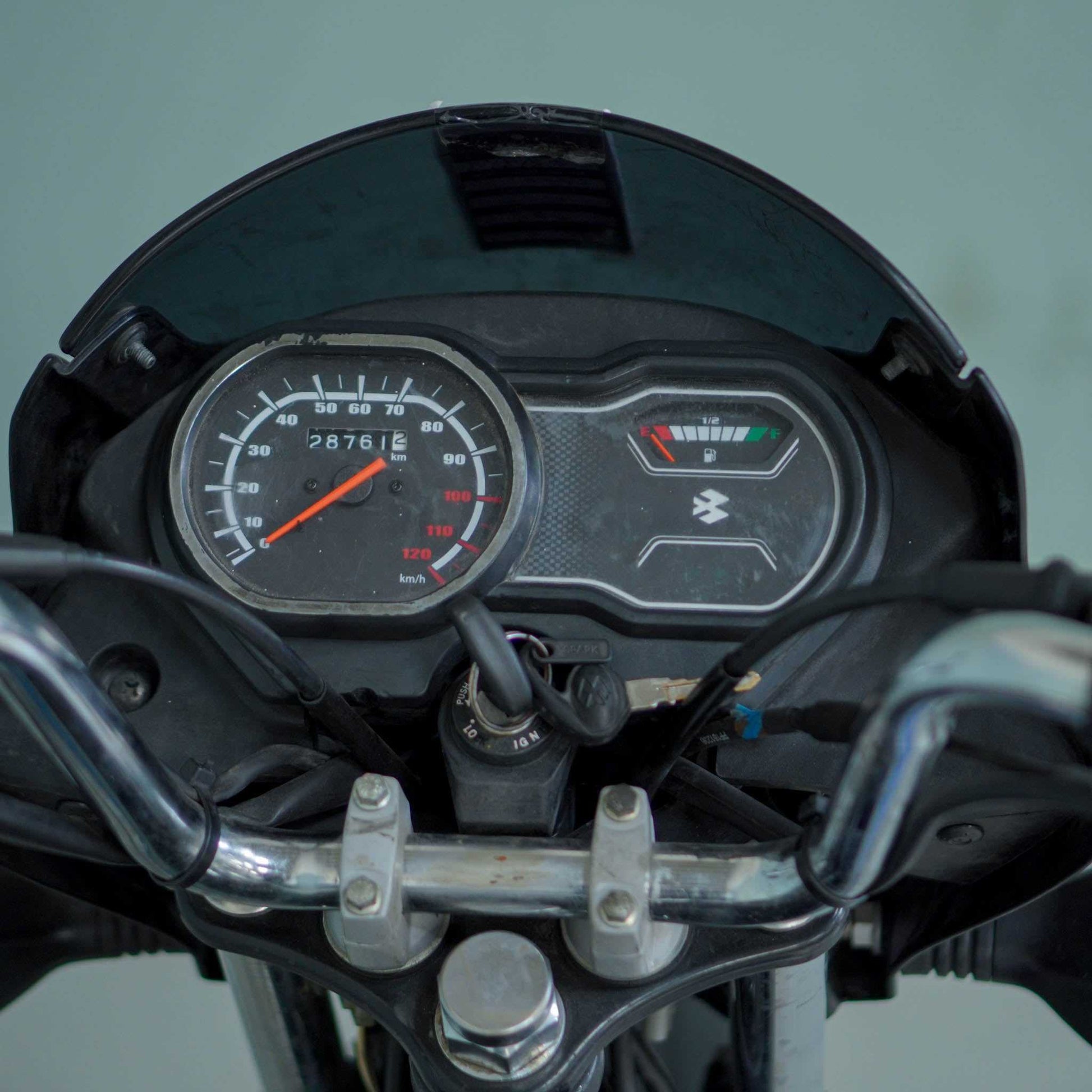 Bajaj Platina motorcycle parked on the road with its sleek design and black and silver color scheme.