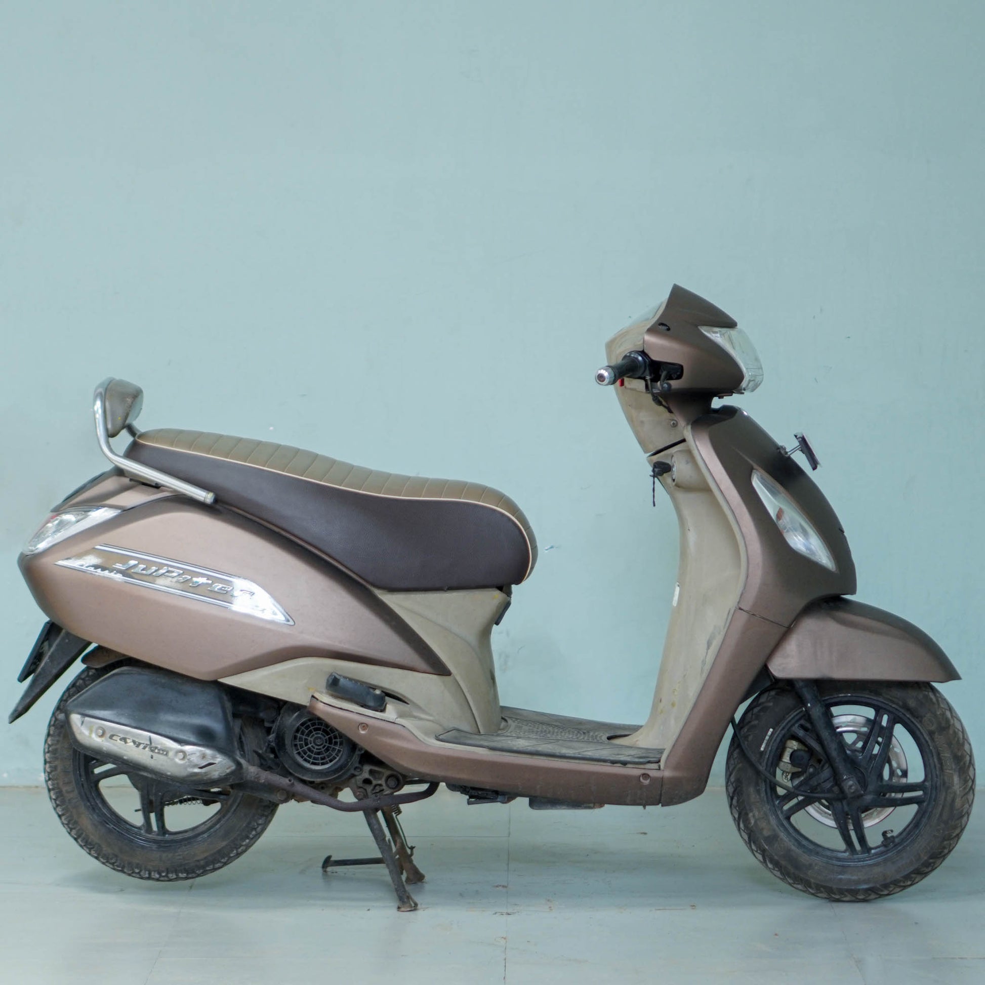 TVS Jupiter Classic scooter parked outdoors, featuring a sleek design and comfortable seating, by BikeDilwado.