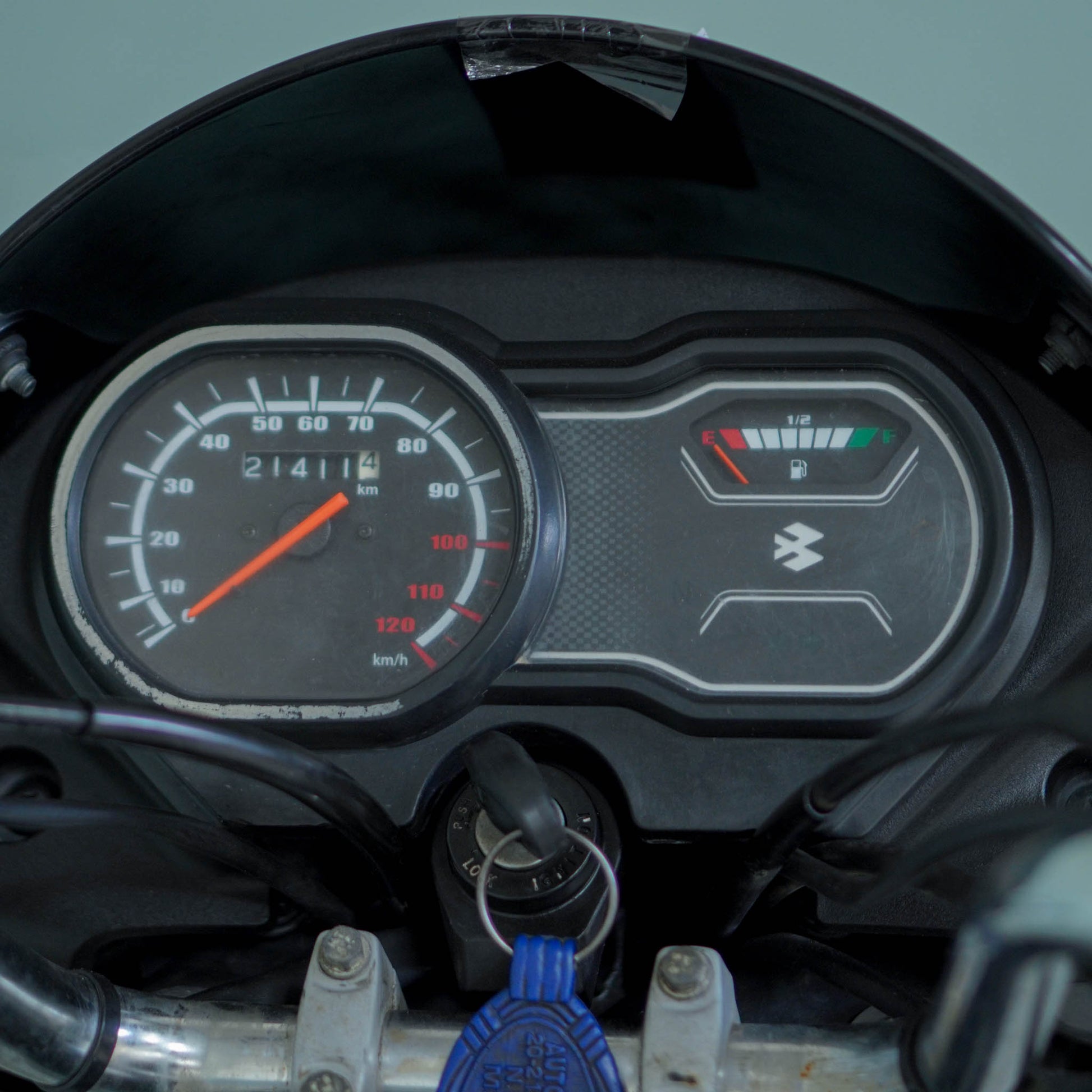 Bajaj Platina motorcycle with black and silver body, front view showing headlight and handlebars, parked outdoors.