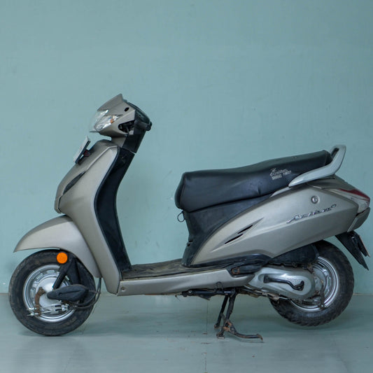 Honda Activa 4G scooter parked on a city street, showcasing its sleek design and modern features.