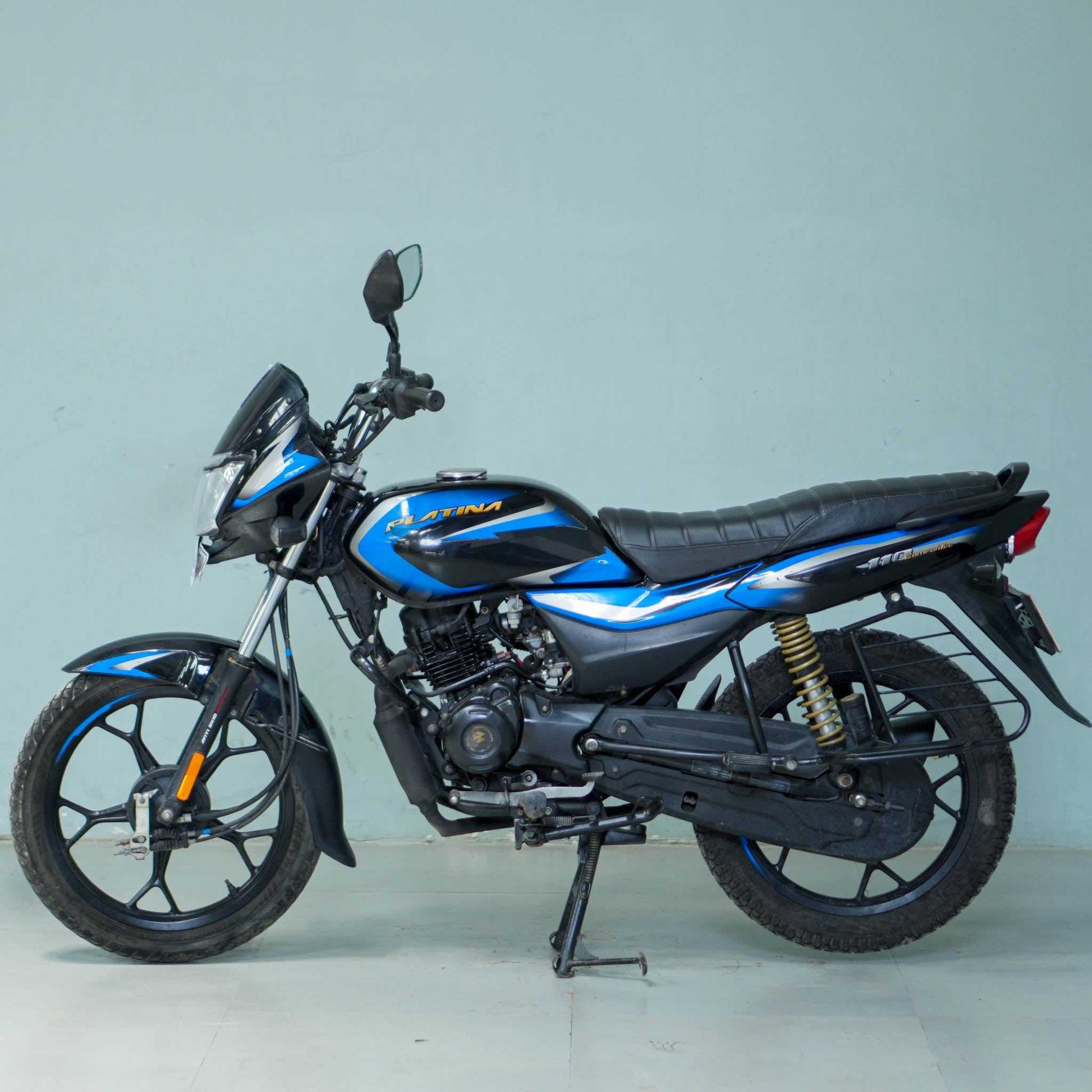 Bajaj Platina motorcycle from BikeDilwado with a sleek black design and comfortable seat, shown from side view.