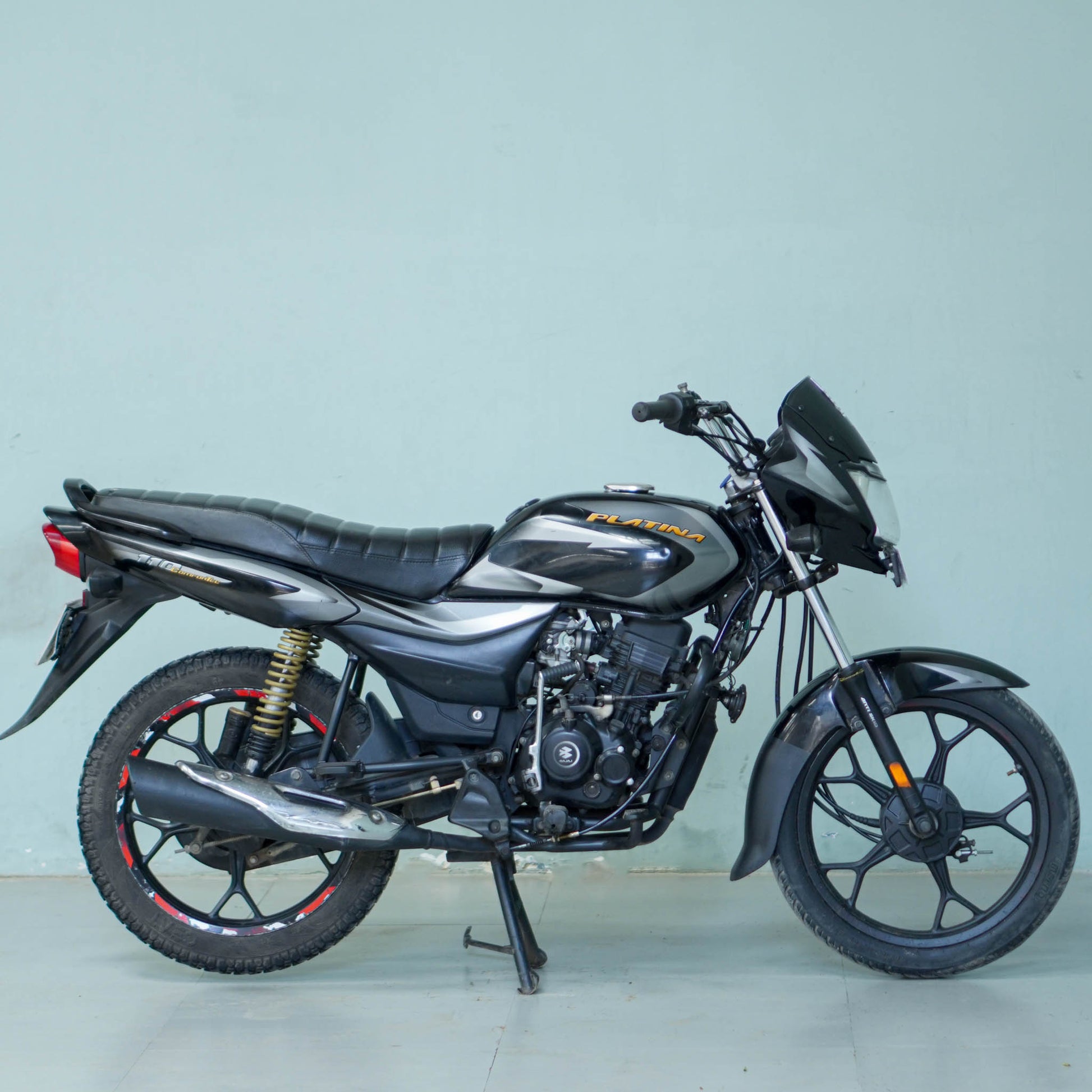 Bajaj Platina motorcycle from BikeDilwado showing the side view with black and silver body design and alloy wheels