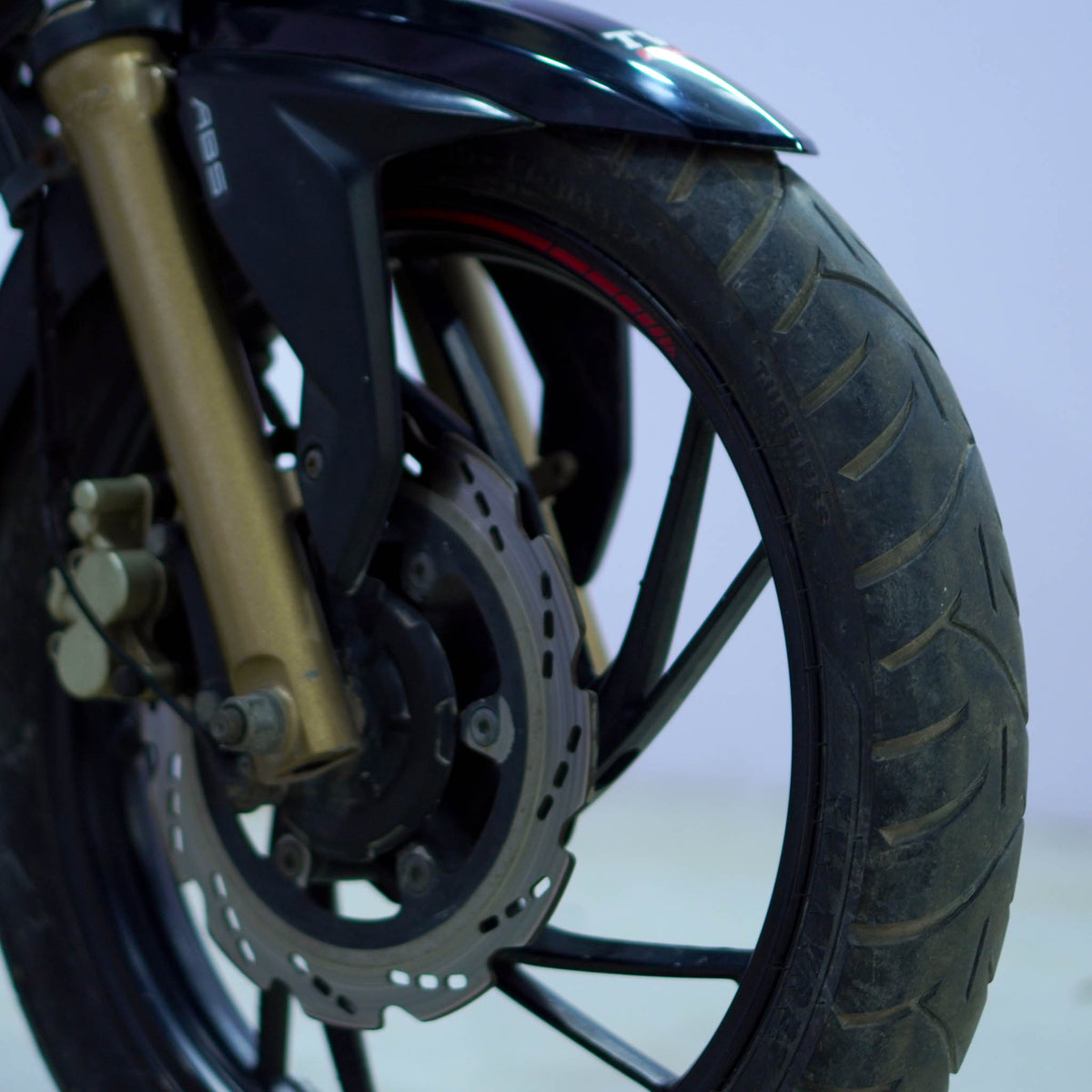 Black TVS Apache 200 4V motorcycle with sleek design and modern features, displayed from a side angle.