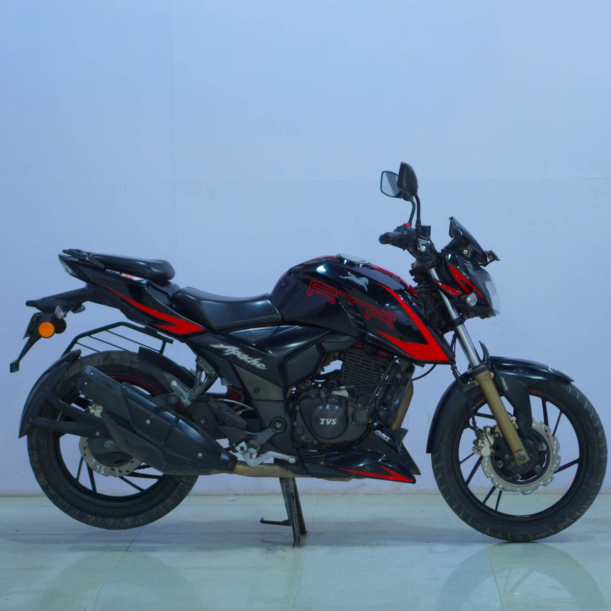 TVS Apache 200 4V motorcycle with sporty design and sleek black finish, featuring digital display and aggressive headlights.