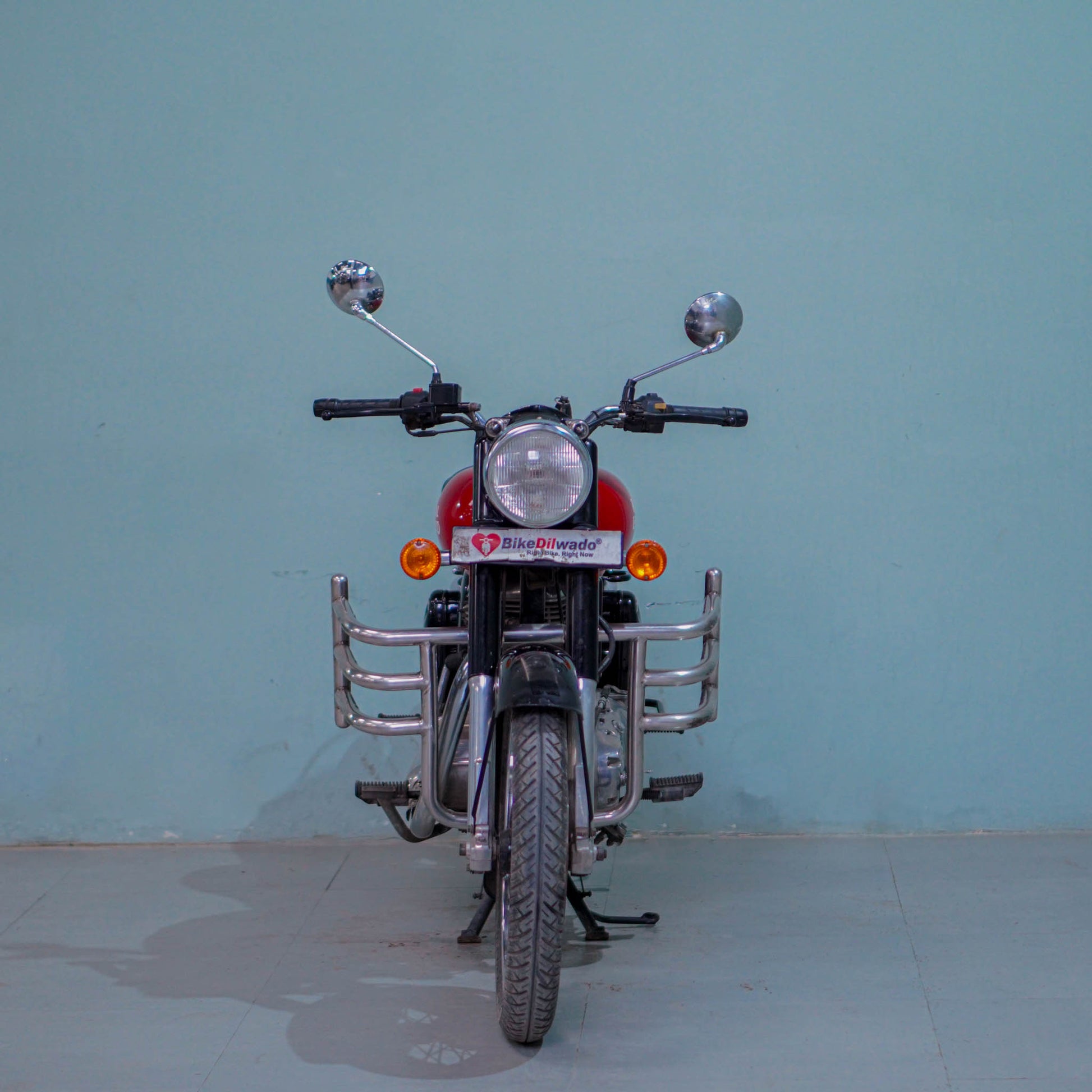 Royal Enfield Classic 350 motorcycle parked outdoors, featuring a vintage design with a black fuel tank and chrome accents.