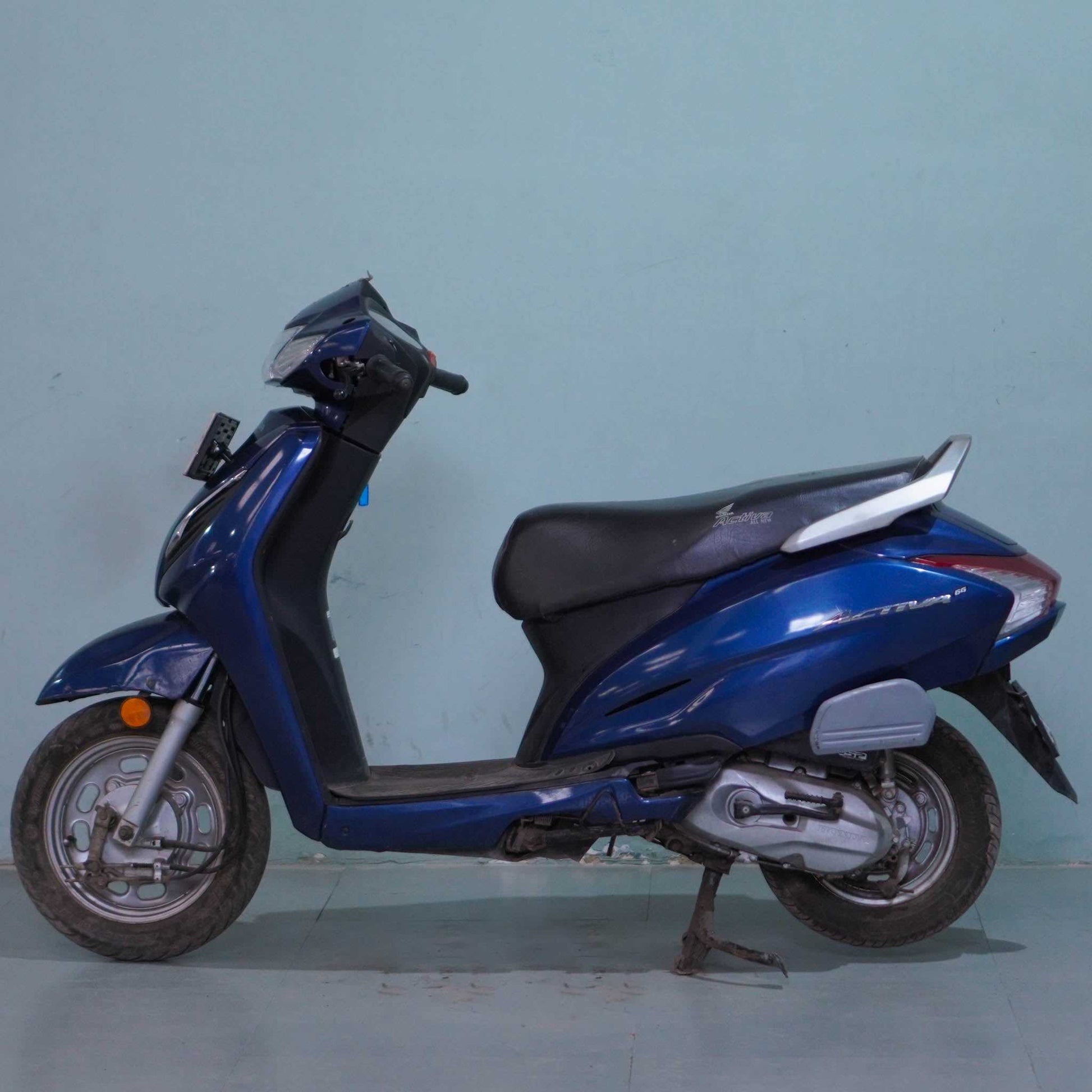 Honda Activa 6G scooter in black with digital dashboard and alloy wheels, showcased from a side angle.
