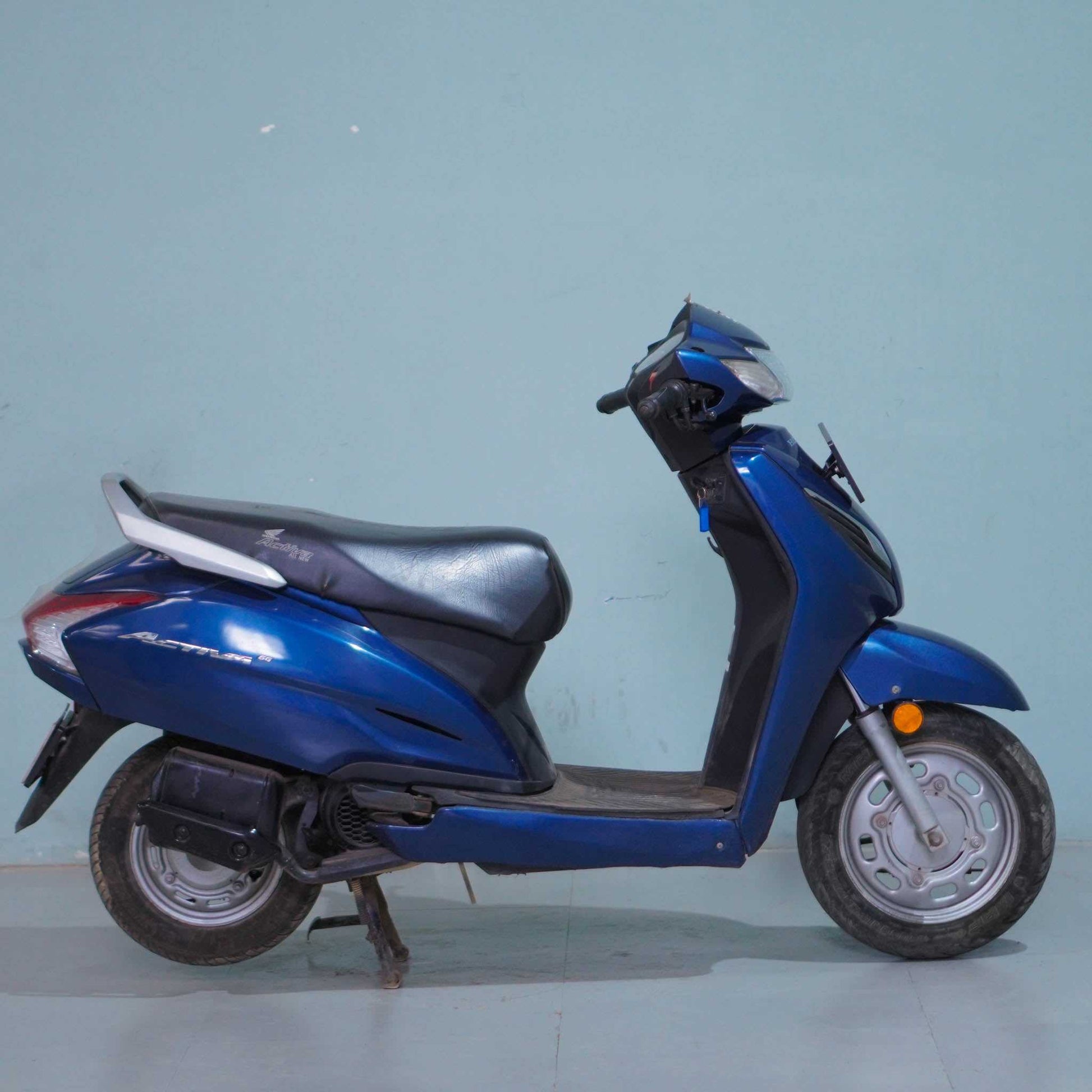 Honda Activa 6G scooter with black body and silver accents, featuring a sleek design and comfortable seating.