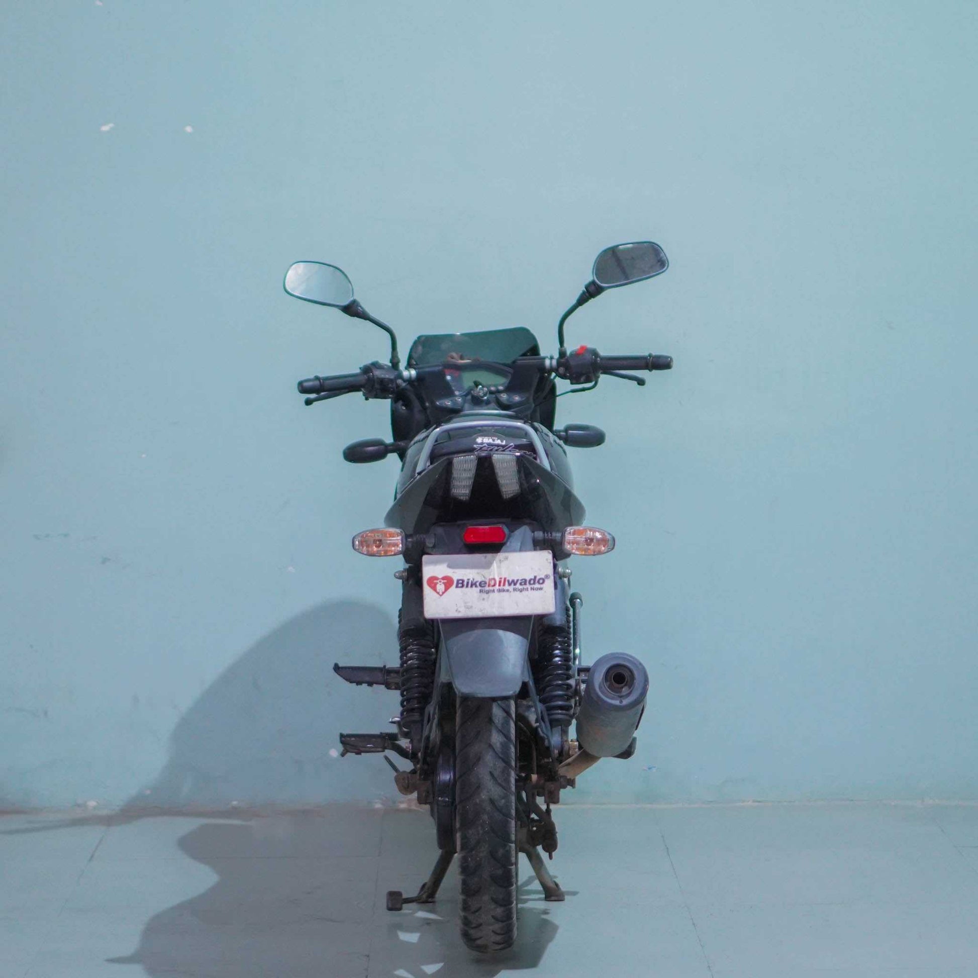 Black Bajaj Pulsar 125 motorcycle with sporty design, featuring a sleek fuel tank, headlight, and handlebar.