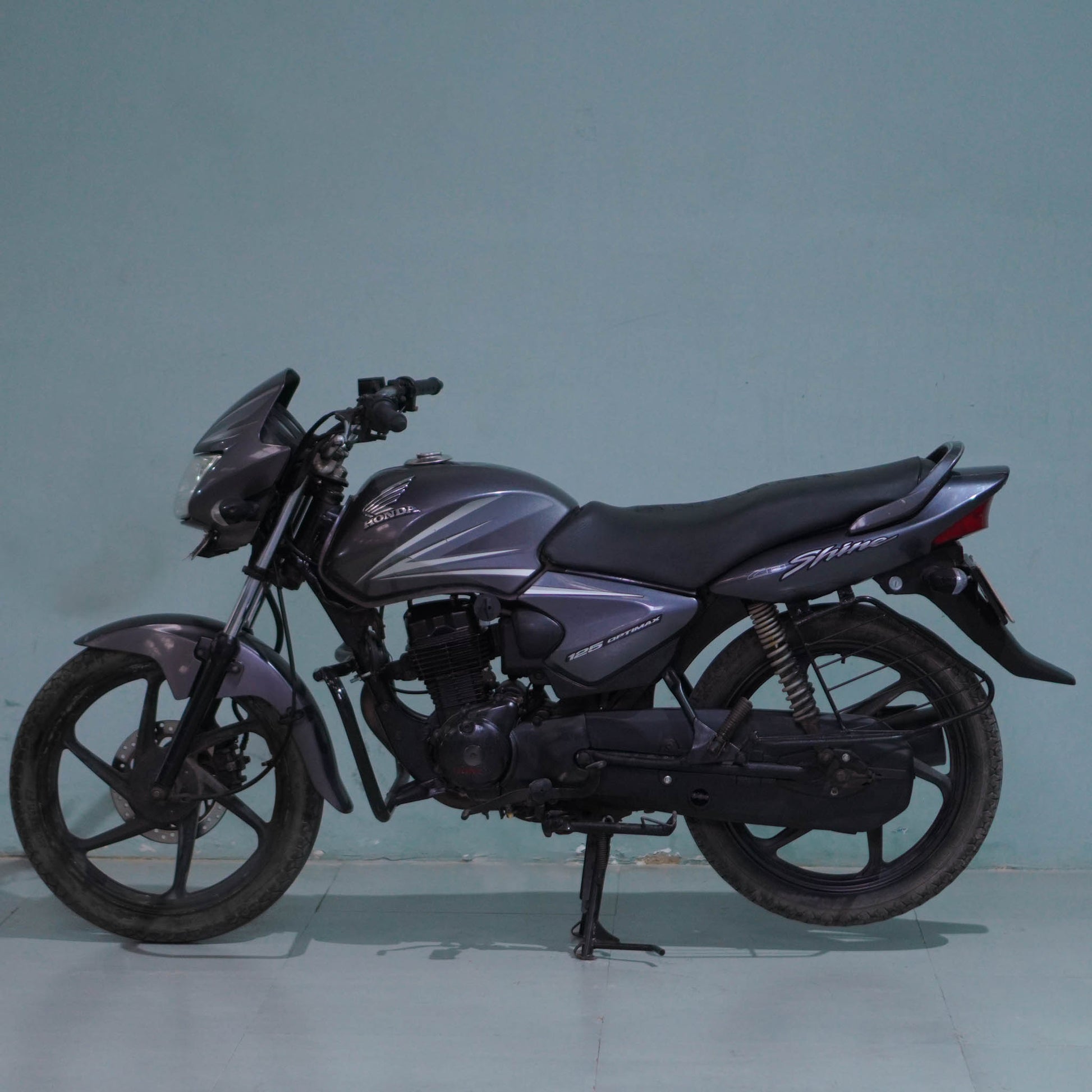 Honda Shine 125 motorcycle from BikeDilwado featuring a sleek design and detailed view of the bike's front and side profile.