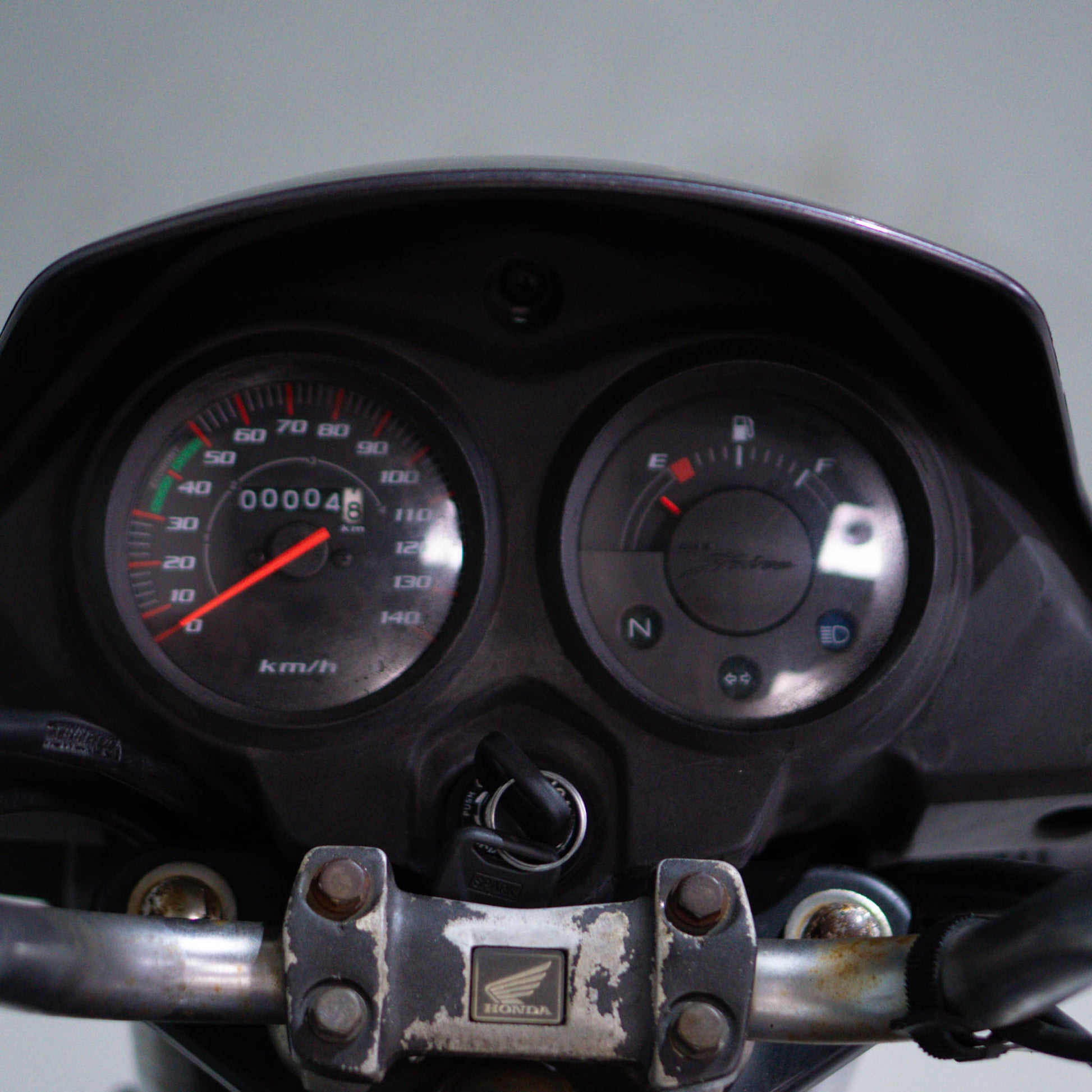 Honda Shine 125 motorcycle viewed from the side, showcasing its sleek silver body and black accents, brand logo visible.